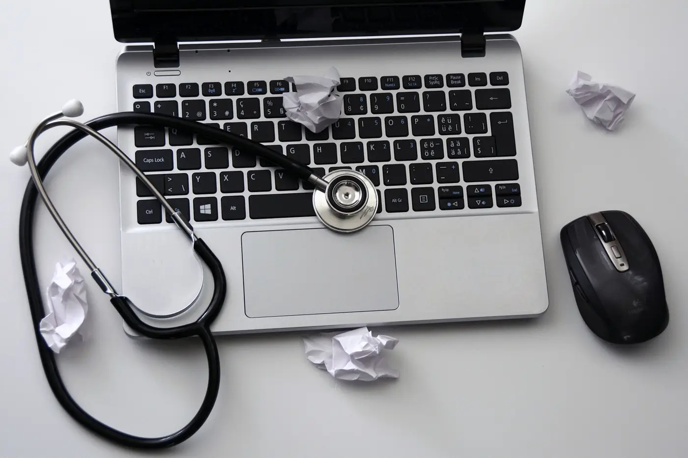 Laptop ze stetoskopem na klawiaturze - symbol serwisu komputerowego
