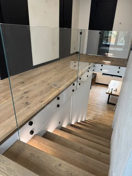 Antresola z balustradą ze szkła nad schodami z podświetleniem