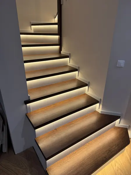 Ciemne stopnie z podświetleniem i czarną balustradą