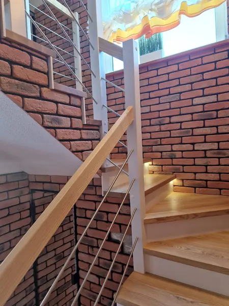 Schody przy ścianie z cegły z balustradą z linek ze stali nierdzewnej